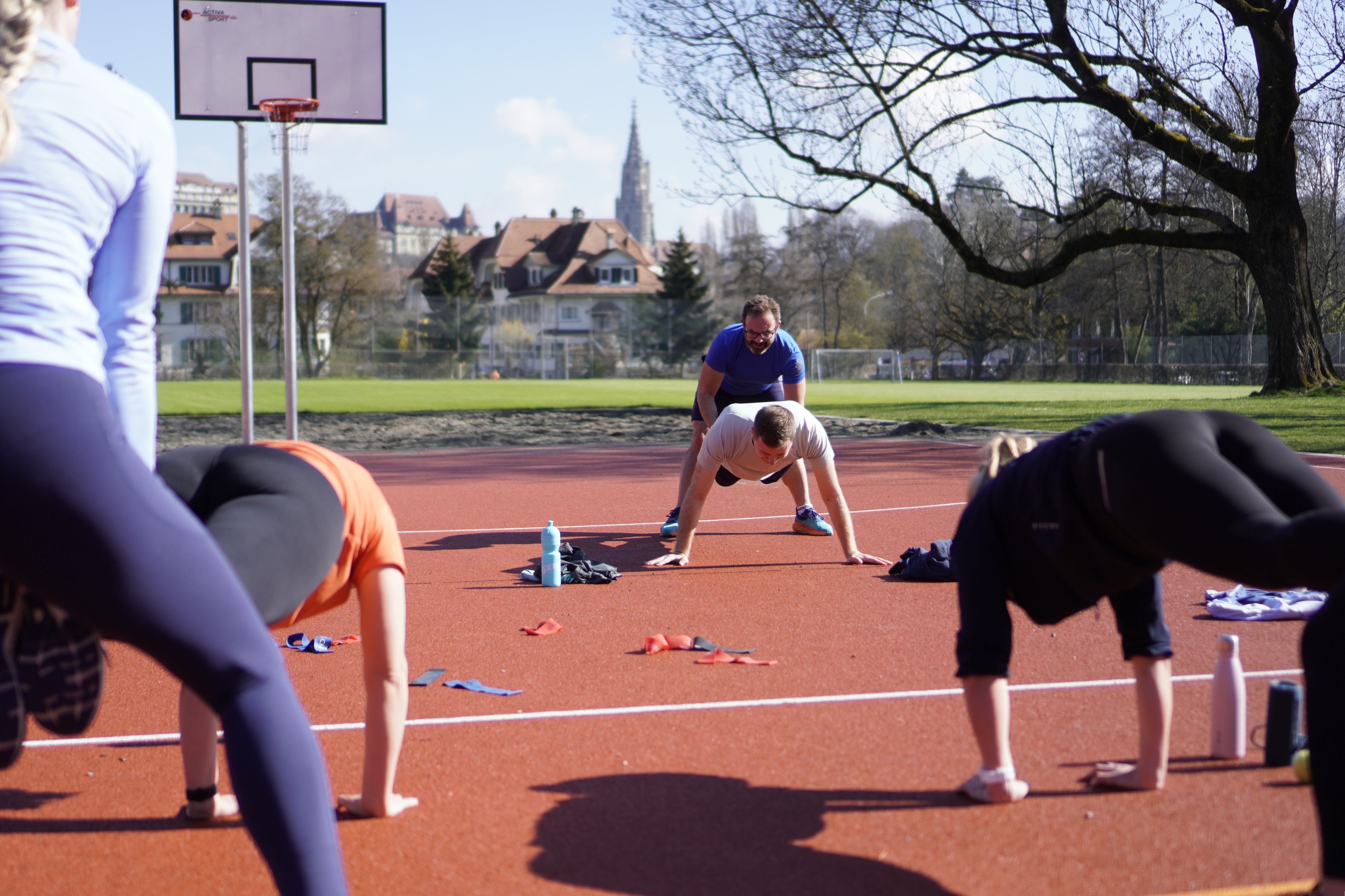 Teilnehmende draussen am Sport machen und Spass haben. Die Übung ist Teil des Funktionellen Outdoortraining Bern